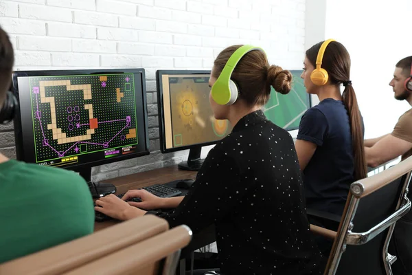 Młodzi ludzie grają w gry wideo na komputerach w pomieszczeniu. Turniej esportowy — Zdjęcie stockowe