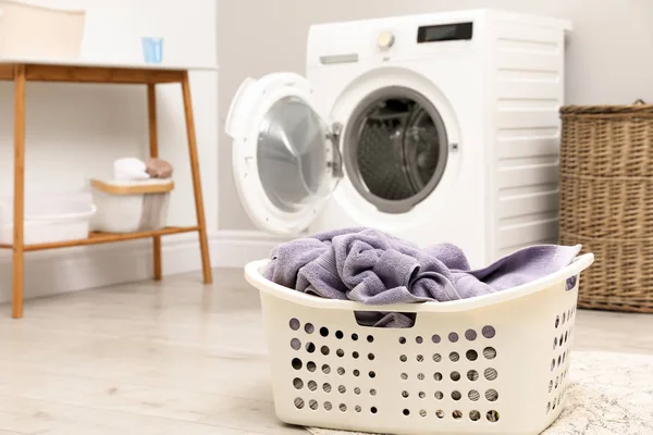 Basket with laundry and washing machine indoors, space for text — Stock Photo, Image