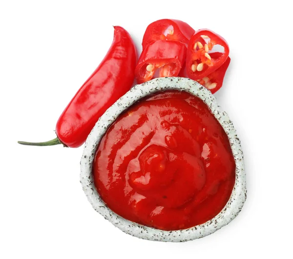 Skål med röd sås och färsk chilipeppar isolerad på vit, uppifrån — Stockfoto