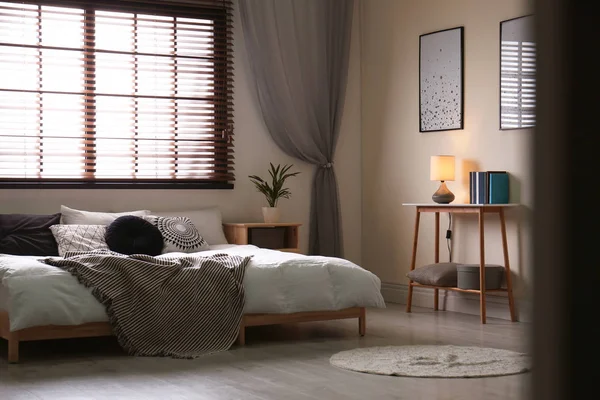 Moderno interior de la habitación con cómoda cama doble y persianas —  Fotos de Stock