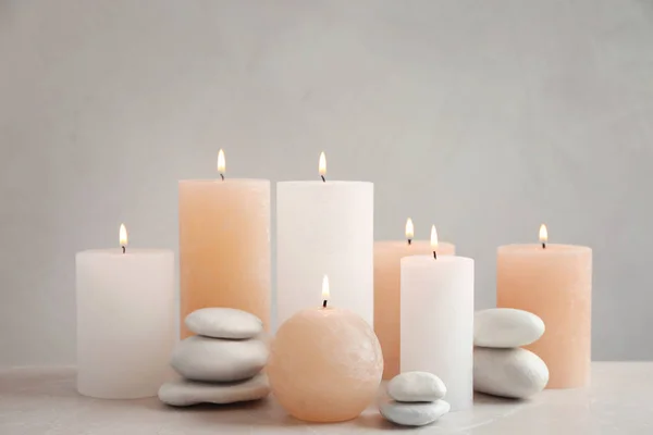 Hermosa composición con velas sobre la mesa sobre fondo gris —  Fotos de Stock