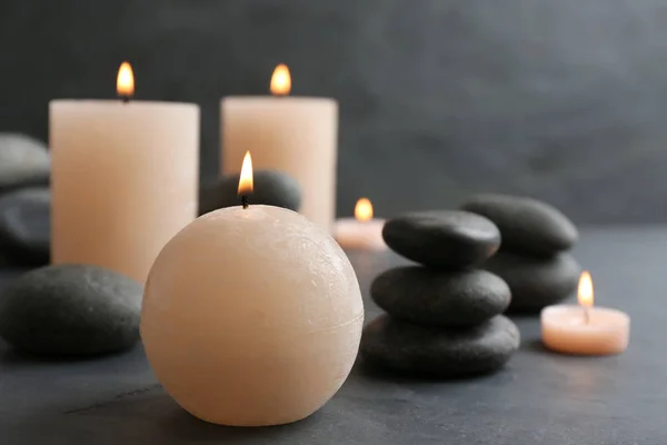 Bela composição com velas e pedras de spa na mesa — Fotografia de Stock