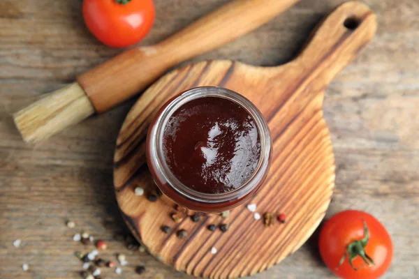 Flat lay composition with barbecue sauce on wooden background — Stock Photo, Image