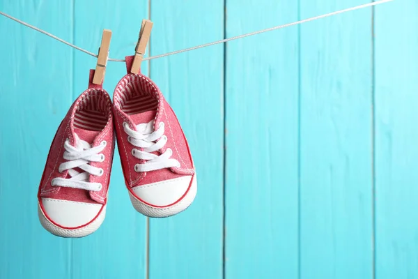 Παπούτσια για μωρά στη γραμμή πλυντηρίου ενάντια στο έγχρωμο ξύλινο φόντο, Χώρος για κείμενο. Παιδικά Αξεσουάρ — Φωτογραφία Αρχείου