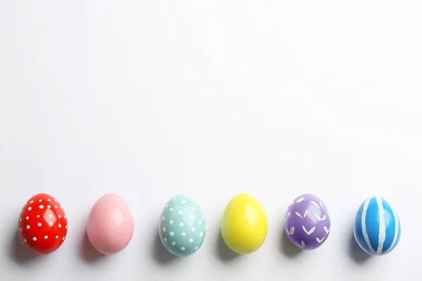 Beyaz arka plan üzerine boyalı Paskalya yumurtaları kompozisyonu, üst görünüm — Stok fotoğraf