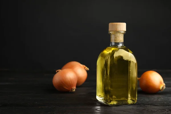 Glass bottle of onion syrup and fresh vegetable on dark background. Space for text — Stock Photo, Image