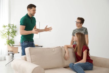 Baba evde onun genç oğlu ve kızı ile konuşuyor