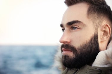 Portre od sakallı yakışıklı adam deniz yakınında, yakın çekim görünümü. Metin için alan