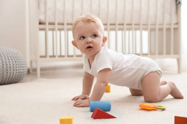 Cute little baby crawling on carpet indoors — Stock Photo, Image