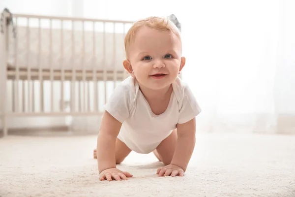 Śliczne małe dziecko pełzające na dywan w pomieszczeniu — Zdjęcie stockowe