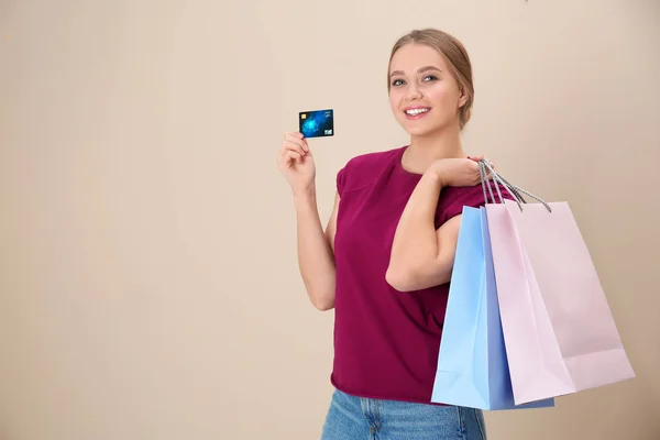 幸福的年轻女子的肖像与信用卡和购物袋上的颜色背景, 文字空间。消费 — 图库照片