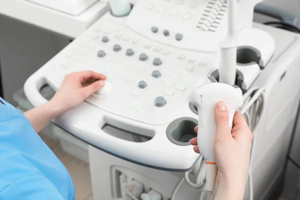 Sonographer operating modern ultrasound machine in clinic, closeup — Stock Photo, Image