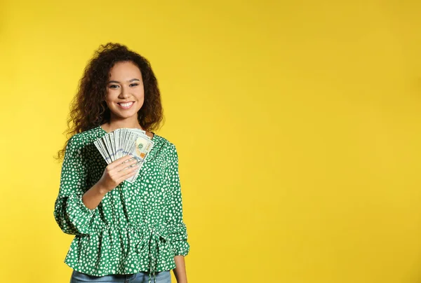 Junge afrikanisch-amerikanische Frau mit Geld auf farbigem Hintergrund. Raum für Text — Stockfoto