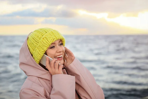 Jovem mulher falando no telefone celular perto do mar — Fotografia de Stock