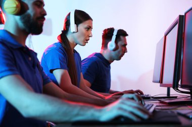 Gençler kapalı bilgisayarlarda video oyunları oynuyorlar. Esports turnuvası