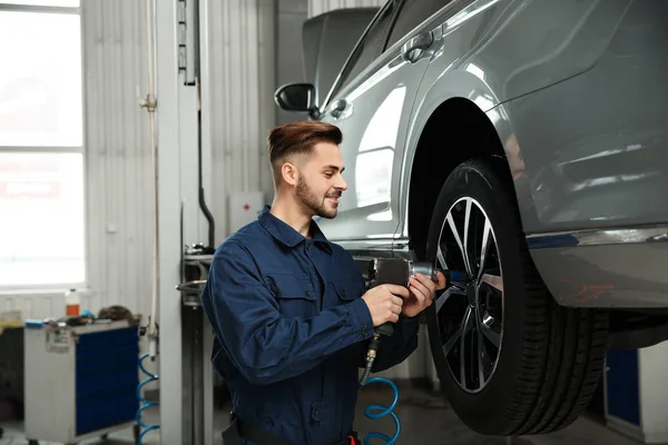 Técnico que trabaja con el coche en el taller de reparación de automóviles —  Fotos de Stock