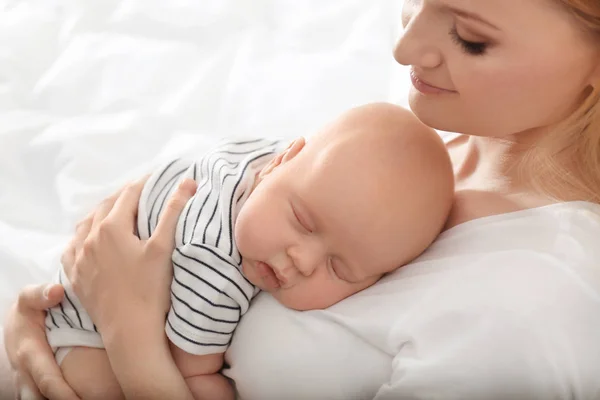 Madre con su bebé dormido om fondo de luz —  Fotos de Stock