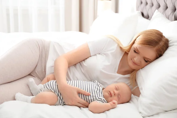 Mother with her baby resting on bed at home — Stock Photo, Image