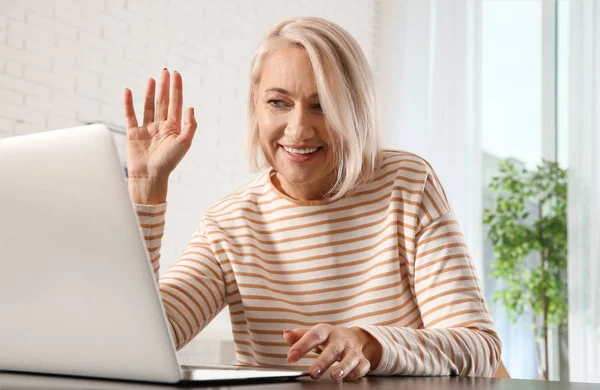 Érett nő használ video chat a laptopon otthon — Stock Fotó