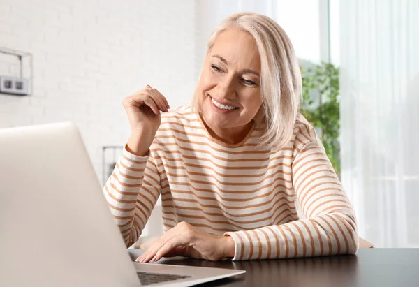 Érett nő használ video chat a laptopon otthon — Stock Fotó