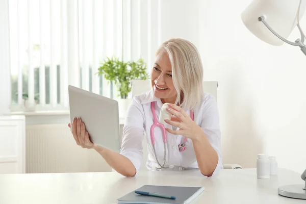 Médico consulta paciente usando vídeo chat em tablet na clínica — Fotografia de Stock