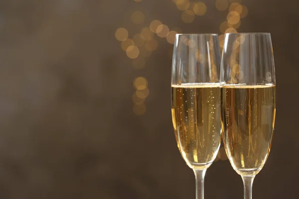Glazen Champagne tegen vervaagde lichten, close-up. Ruimte voor tekst — Stockfoto