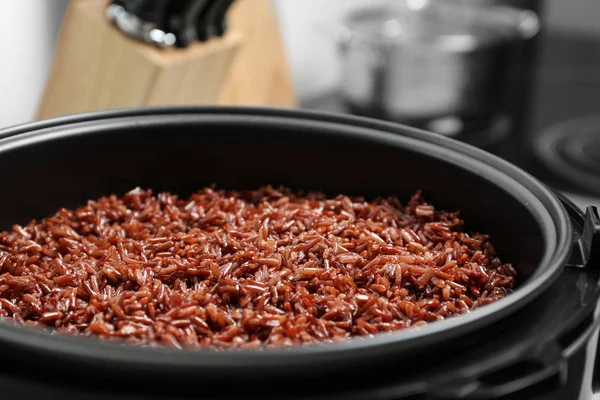 Modern multi cooker with boiled brown rice in kitchen, closeup — Stock Photo, Image