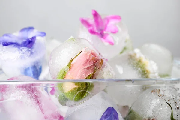Cuenco de vidrio con cubitos de hielo florales sobre fondo claro, primer plano — Foto de Stock