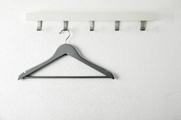 Стойка с пустой вешалкой для одежды на светлой стене. Шкаф для одежды — стоковое фото