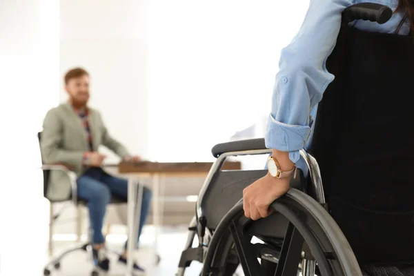 Jonge vrouw in rolstoel met collega op kantoor, close-up — Stockfoto