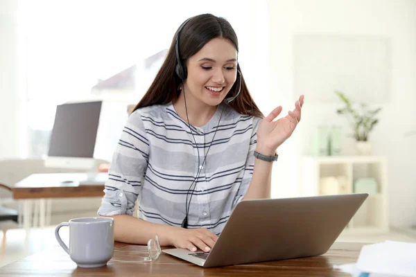 Giovane donna che utilizza la video chat sul computer portatile in home office — Foto Stock