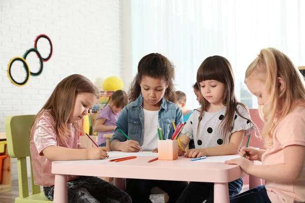Adorable children drawing together at table indoors. Kindergarten playtime activities — Stock Photo, Image