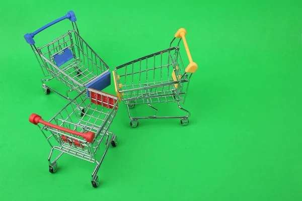 Carritos de compras vacíos sobre fondo de color, por encima de la vista. Espacio para texto —  Fotos de Stock