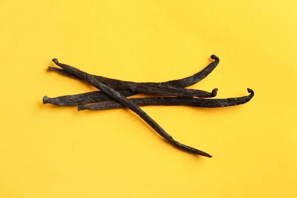 Manojo de varillas de vainilla aromáticas sobre fondo amarillo — Foto de Stock