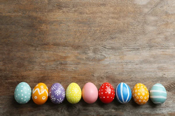 Ahşap masa üzerinde boyalı Paskalya yumurtaları Düz yatıyordu kompozisyon, metin için alan — Stok fotoğraf
