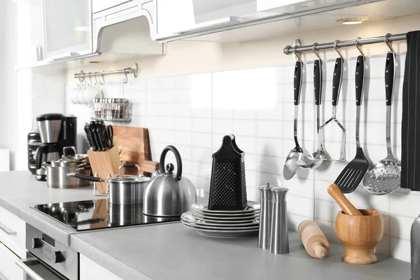 Different appliances, clean dishes and utensils on kitchen counter — Stock Photo, Image