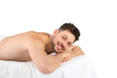 Yakışıklı adam beyaz arka plan karşı masaj masasında rahatlatıcı. Spa hizmeti
