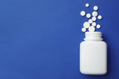 Renkli arka planda farklı haplar ile Şişe, düz yatıyordu. Metin için alan