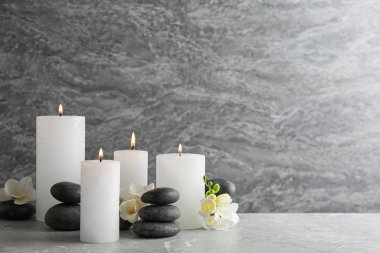 Yanan mumlar, spa taşları ve çiçeklerin bileşimi. Metin için alan