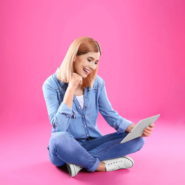 Женщина, использующая планшет для видеочата на цветном фоне — стоковое фото