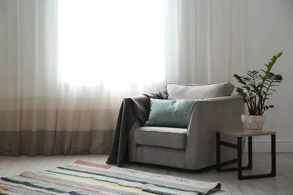 Acogedor sillón con almohadas y cuadros cerca de la ventana en la habitación. Diseño de interiores —  Fotos de Stock