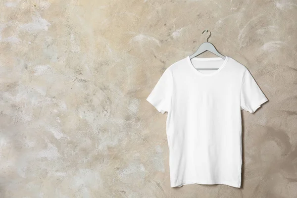 Hanger with white t-shirt on color background. Mockup for design — Stock Photo, Image