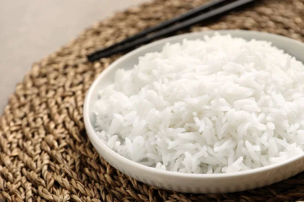 Prato de arroz cozido saboroso no tapete de vime, close-up — Fotografia de Stock