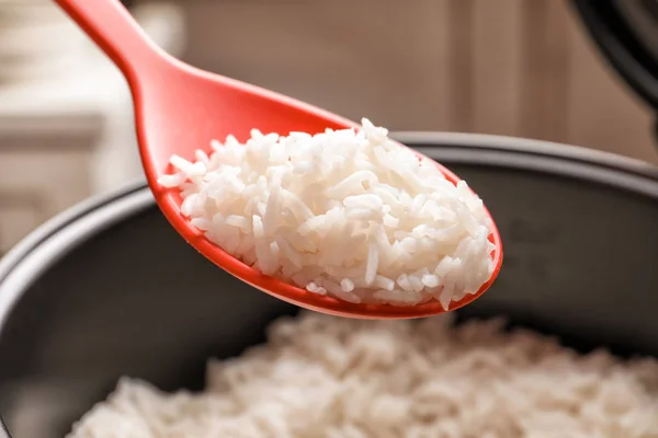 Sendok dengan nasi panas lezat di atas kompor, closeup — Stok Foto