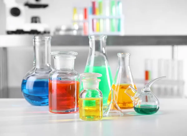 Různé skleněné zboží se vzorky na tabulce v chemické laboratoři — Stock fotografie