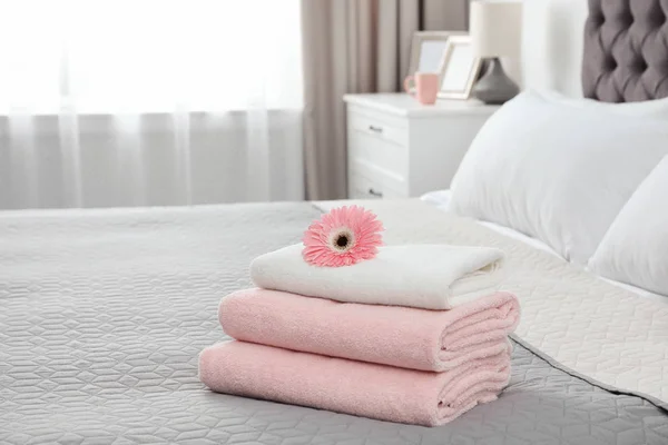Pino puhtaita pyyhkeitä kukka sängyssä sisätiloissa. Tekstitila — kuvapankkivalokuva