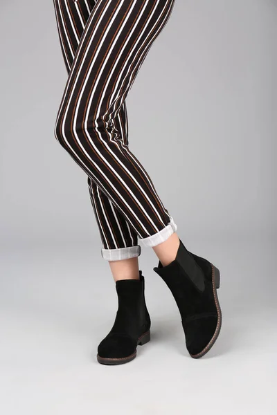 Žena ve stylových botách na světlém pozadí — Stock fotografie