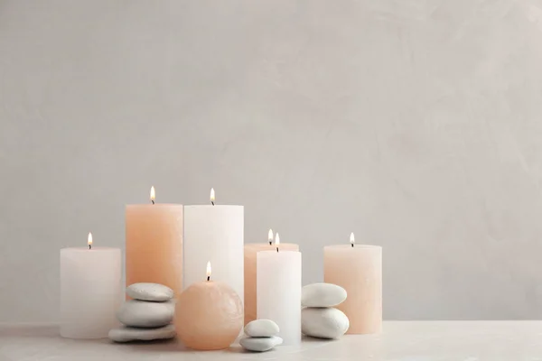 Hermosa composición con velas sobre la mesa sobre fondo gris. Espacio para texto —  Fotos de Stock