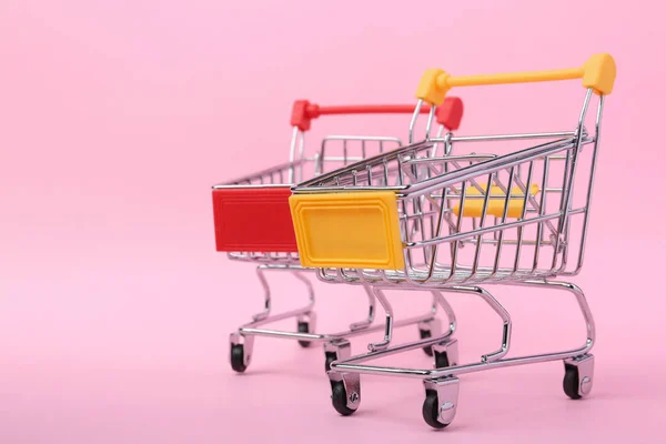 Empty shopping trolleys on color background. Space for text — Stock Photo, Image