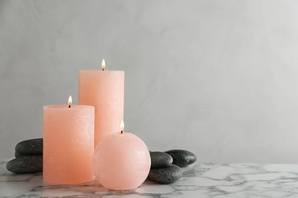 Склад спалюваних свічок і спа-камінців на столі. Простір для тексту — стокове фото